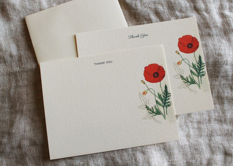 May include: Two blank thank you cards with a red poppy flower illustration. The text "Thank You" is printed on each card.