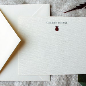 Pu&ograve; includere: Carta da lettere bianca con un'illustrazione di coccinella rossa e il nome "KAYLEIGH DUMOND" stampato in nero.