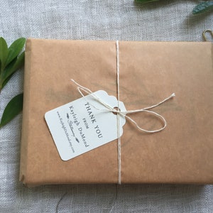 May include: A brown paper package tied with twine and a white gift tag that reads "Thank You from Kayleigh DuMond Stationery".