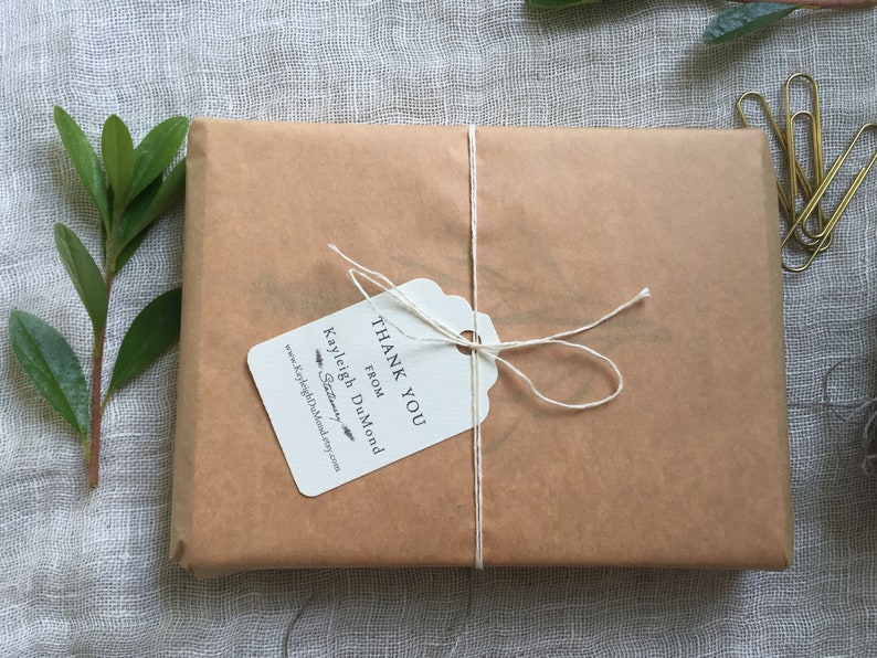 May include: A brown paper package tied with twine and a white gift tag that reads "Thank You from Kayleigh DuMond Stationery".