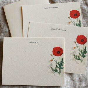 May include: Set of three blank stationery cards with a red poppy flower illustration and the name "Cassie T. Summers" printed on two of the cards. The third card says "Thank You".
