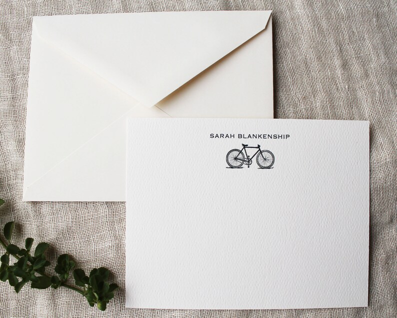 May include: White stationery card with a black bicycle illustration and the text "SARAH BLANKENSHIP" printed in black.