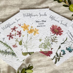 May include: Four seed paper cards with different flower illustrations and the text "Wildflower Seeds". The cards have the names of the flowers and the date "6.29.2028" printed on them.