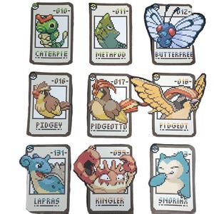 May include: A collection of nine rectangular patches featuring pixel art illustrations of creatures. Each patch displays a unique character with its name and number, including Caterpie, Metapod, Butterfree, Pidgey, Pidgeotto, Pidgeot, Lapras, Kingler, and Snorlax.
