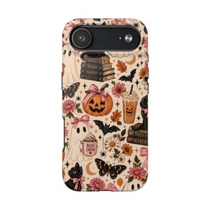 Peut inclure: Une coque de téléphone au fond crème avec un motif répétitif d'icônes d'Halloween incluant des fantômes, des citrouilles avec des nœuds roses, des chats noirs, des chauves-souris, des papillons, des fleurs, des lunes et des livres Spooky Books Happy Thoughts.