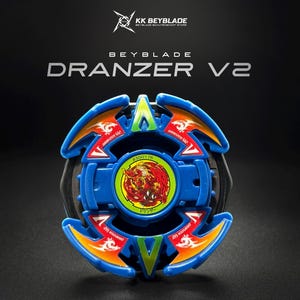 May include: A blue Beyblade Dranzer V2 spinning top toy featuring a central circular emblem with a red phoenix graphic, green accents, and orange details. The text "BEYBLADE DRANZER V2" and "KK BEYBLADE" are printed above the toy on a black background.