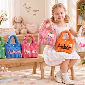 May include: A collection of six small corduroy handbags in green, blue, pink, orange, and white. Each bag features a snap closure, two handles, and a personalized name in raised lettering, including Coral, Avery, Vivian, Ariana, Amber, and Luna.