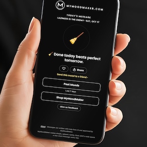 May include: A smartphone displaying the MyMoodMaker app interface with a black background. The screen shows the text 'TODAY'S MESSAGE LAZINESS IS THE ENEMY - SAT, OCT 17', a broom icon, and the phrase 'Done today beats perfect tomorrow.'