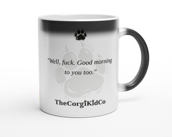 May include: A white ceramic mug with a black gradient rim and handle. The front features a black paw print icon, the text "Well, fuck. Good morning to you too." in a serif font, and the brand name "TheCorgiKidCo" printed in black at the bottom.