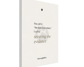 May include: A rectangular white canvas wall art piece featuring a small black paw print icon at the top. The text reads: You call it "the trash everywhere." I call it securing the evidence. A large, faint paw print is centered behind the text.