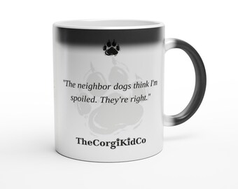 May include: A white ceramic mug with a black gradient rim and handle. It features a black paw print icon, the text "The neighbor dogs think I'm spoiled. They're right." in black serif font, and the black text "TheCorgiKidCo" at the bottom.