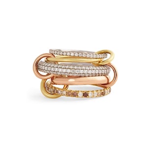 Puede incluir: Un anillo de múltiples bandas que presenta cinco aros circulares interconectados en oro amarillo, rosa y blanco. El diseño incluye dos bandas incrustadas con diamantes blancos transparentes, una banda de oro rosa lisa y una banda con diamantes marrones.