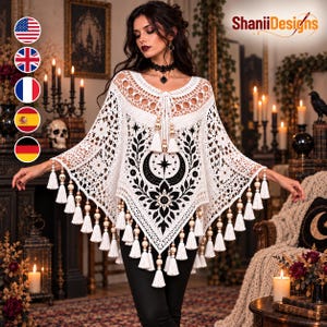 Può includere: Un poncho all'uncinetto bianco con un motivo centrale a mezzaluna e stella nera, circondato da disegni floreali. Il capo presenta un'ampia scollatura con coulisse, perline a forma di teschio e lunghe frange lungo i bordi.