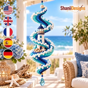 May include: A hanging crochet spiral ornament featuring a central lighthouse surrounded by waves in shades of blue, turquoise, and white. The design includes small white beads, a starfish accent, and a faceted blue crystal drop at the bottom.