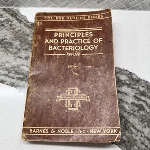 May include: A brown softcover book titled Principles and Practice of Bacteriology, Revised, from the College Outline Series by Bryan. The cover features white text, the Barnes & Noble Inc New York imprint, and a logo with the text The Student's Private Tutor.