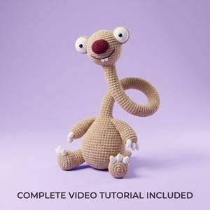 Puede incluir: Un peluche de ganchillo color canela con cuello largo, ojos blancos grandes, nariz roja oscura y dos dientes blancos pequeños. La criatura tiene cuerpo redondeado, cola enroscada y garras blancas en manos y pies. Texto: COMPLETE VIDEO TUTORIAL INCLUDED.