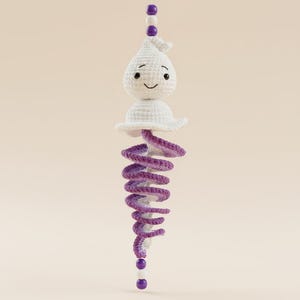 May include: A crocheted ghost ornament featuring a white head with embroidered black eyes and a smile, topped with purple and white beads. Below the ghost is a spiraling purple and white crochet tail, finished with purple and white beads.