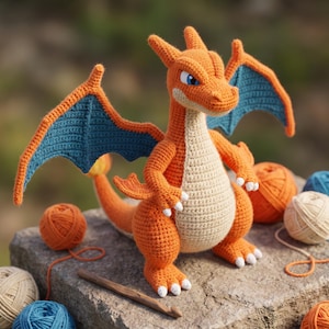 May include: A crocheted orange dragon figure with a cream-colored belly, blue-lined wings, and white claws. The creature has a long tail with a flame-like tip, pointed ears, and blue eyes. It stands upright with a wooden crochet hook nearby.