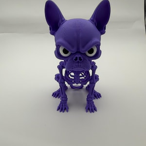 May include: A purple 3D printed figurine of a French Bulldog with a skeletal body structure. The figure features large pointed ears, a stern facial expression, and white circular eyes. The surface shows visible horizontal layer lines from the printing process.