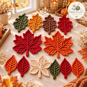 Könnte beinhalten: Eine Sammlung verschiedener gehäkelter Herbstblätter in den Farben Rot, Orange, Gelb, Braun, Grün und Creme. Das Set enthält große Ahornblätter und kleinere, oval geformte Blätter mit sichtbaren Garnstrukturen und komplexen Maschenmustern.