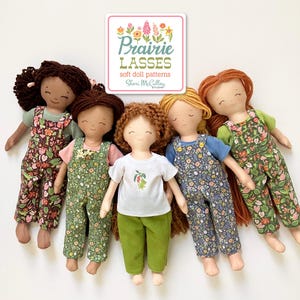 Peut inclure: Cinq poupées en tissu faites à la main portant des salopettes et des tissus à motifs différents. Les poupées ont les cheveux bruns, blonds et roux. Les poupées sont disposées en cercle sur un fond blanc. Le texte "Prairie Lasses soft doll patterns Sheri McCulley Studio" est sur une étiquette rose et verte au-dessus des poupées.