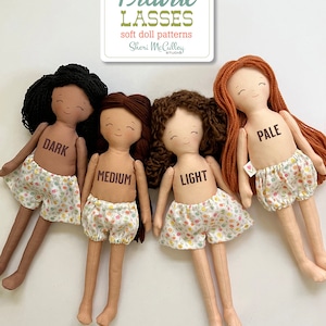 May include: Four handmade dolls with different skin tones, labeled "Dark", "Medium", "Light", and "Pale". The dolls are wearing matching floral print shorts and have different hair colors and styles. The image is titled "Doll Skin Tones" and includes the logo for "Prairie Lasses" soft doll patterns.