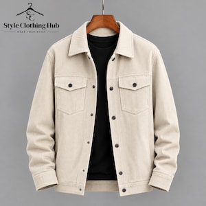 May include: A beige corduroy jacket featuring a pointed collar, long sleeves, and a button-front closure. The jacket includes two chest pockets with buttoned flaps and dark buttons. A black shirt is visible underneath the open jacket.