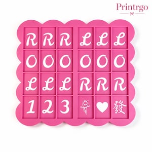 May include: A rectangular pink silicone mold with a scalloped edge featuring a grid of twenty-four recessed cavities. The cavities contain white raised letters R, L, O, numbers 1, 2, 3, a heart shape, a stylized character, and a symbol.
