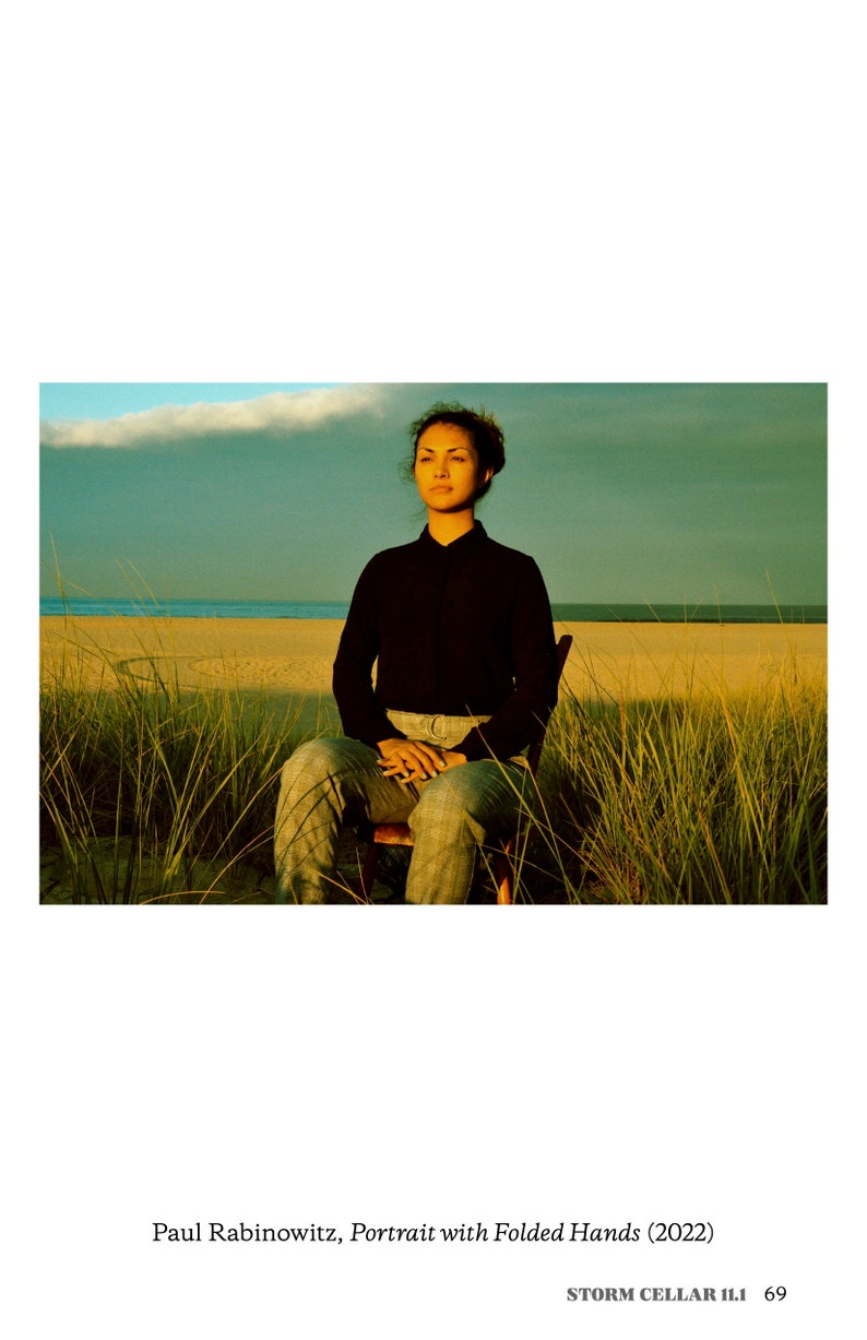 "Portrait with Folded Hands" by Paul Rabinowitz. Photo of a woman sitting in a field looking at the sunset.