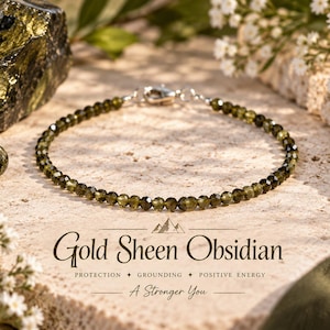 May include: A delicate bracelet composed of small, faceted olive-green beads with a metallic silver-toned lobster clasp. The text Gold Sheen Obsidian, PROTECTION, GROUNDING, POSITIVE ENERGY, and A Stronger You is printed below the bracelet.