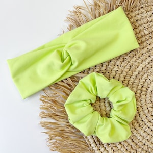 May include: A lime green headband and scrunchie set. The headband is knotted and the scrunchie is made of soft fabric.