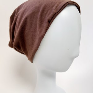 Slouchy beanie gemaakt van een mix van biologisch katoen en bamboe in een neutrale bruine kleur. Uniseks muts / beanie met capuchon / paardenstaartbeanie / nekbeschermer