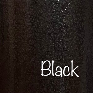May include: A close-up of a black textured surface with the word "Black" written in white.