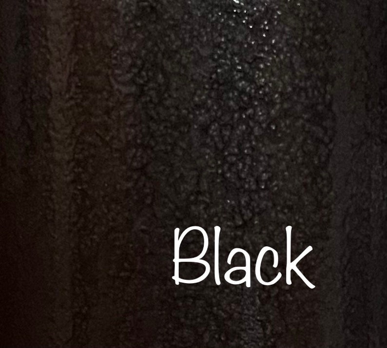 May include: A close-up of a black textured surface with the word "Black" written in white.