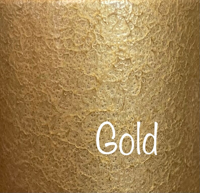 May include: A close-up of a textured gold surface with the word "Gold" written in white.