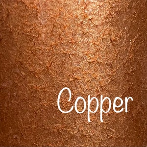 May include: A close-up of a copper-colored surface with a textured, metallic finish. The word "Copper" is written in white text on the surface.