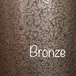 May include: A close-up of a textured, metallic surface in a bronze color. The word "Bronze" is written in white text.