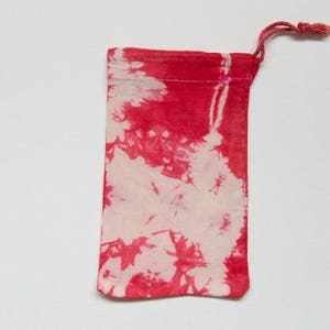 Könnte beinhalten: Eine rot-weiße Batik-Kordeltasche mit weißem Hintergrund und roten Batik-Mustern.