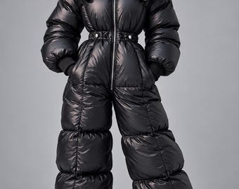 Könnte beinhalten: Ein schwarzer, durchgehender, isolierter Stepp-Jumpsuit mit einem hohen, übergroßen Kragen, einem zentralen silbernen Reißverschluss und einer taillierten Passform mit Druckknopfdetails. Das Kleidungsstück hat lange Ärmel mit Rippbündchen.