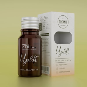May include: A brown glass bottle with a silver cap and a white cardboard box labelled Zhi thera Uplift. The packaging features text including 10 ml / 0.34 fl oz, 100% pure, vegan, and cruelty free. The box displays an organic ingredients logo and a barcode.