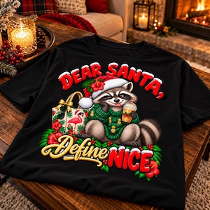 Könnte beinhalten: Ein schwarzes T-Shirt mit einer Grafik eines Waschbären, der eine Weihnachtsmütze und einen grünen Pullover trägt und ein Getränk hält. Der Text lautet Dear Santa, Define NICE. Das Design zeigt eine Geschenktüte mit Flamingo, Hibiskusblüten und Blättern.