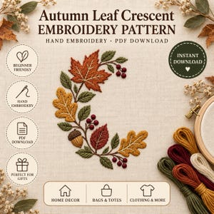 May include: An embroidery pattern titled Autumn Leaf Crescent featuring a crescent-shaped arrangement of stitched maple, oak, and serrated leaves in orange, yellow, and red, accented with small dark red berries and a brown acorn on light fabric.