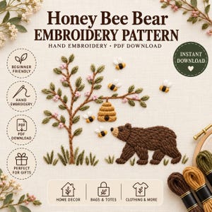 Könnte beinhalten: Honey Bee Bear EMBROIDERY PATTERN HAND EMBROIDERY PDF DOWNLOAD. Ein handgesticktes Design auf Stoff mit einem braunen Bären, einem Bienenstock, der an einem Baum mit rosa Blüten und grünen Blättern hängt, und mehreren kleinen Bienen.