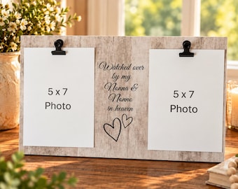 Op de afbeelding: Een rechthoekige fotolijst met een lichte houtnerf en twee zwarte metalen clips voor het ophangen van 13x18 cm foto's. Het middenpaneel bevat de zwarte tekst "Watched over by my Nonna & Nonno in heaven" boven twee handgetekende hartjes.