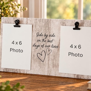 May include: A rectangular light wood grain photo frame with two black metal clips holding white paper inserts labeled 4 x 6 Photo. The center features black text reading Side by side on the best days of our lives with two hand-drawn heart outlines.