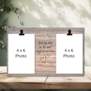 May include: A wooden photo frame with two 4 x 6 photo slots. The frame has black clips to hold the photos. The text "Side by side on the best days of our lives" is written on the frame, along with two hearts.