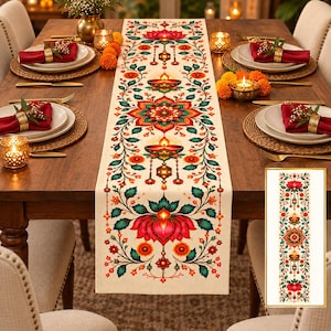 May include: A rectangular table runner featuring a symmetrical, colourful floral pattern with red lotus flowers, orange marigolds, and teal leaves on a cream background. The design includes glowing diya lamp illustrations and intricate decorative motifs.