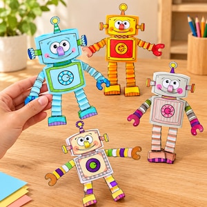 Puede incluir: Cuatro robots de papel en azul claro, amarillo, rosa y beige, cada uno con brazos y piernas plegados en acordeón, diales circulares en el pecho y antenas. Los robots tienen caras sonrientes con ojos grandes y están hechos de cartulina.
