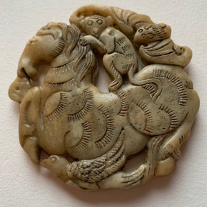 Jade pendant representing a monkey riding a horse