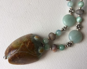 Superbe cigale de jade à deux tonnes sur un collier richement texturé